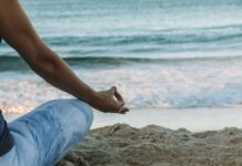 명상의 효과: 집중력과 스트레스 감소 person in blue shorts sitting on beach shore during daytime