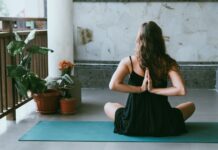실내에서 즐기는 간단 요가 루틴 woman wearing black shirt sitting on green yoga mat