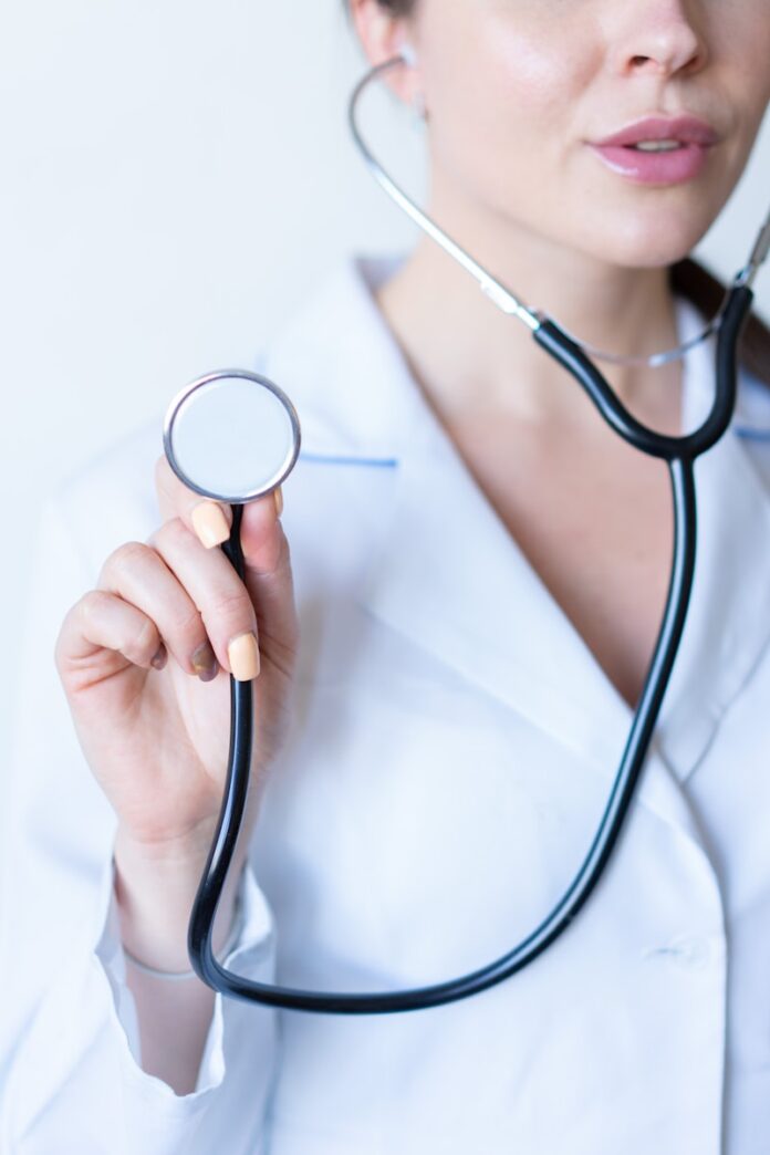 Photo by Alexandr Podvalny a woman in a white shirt holding a stethoscope